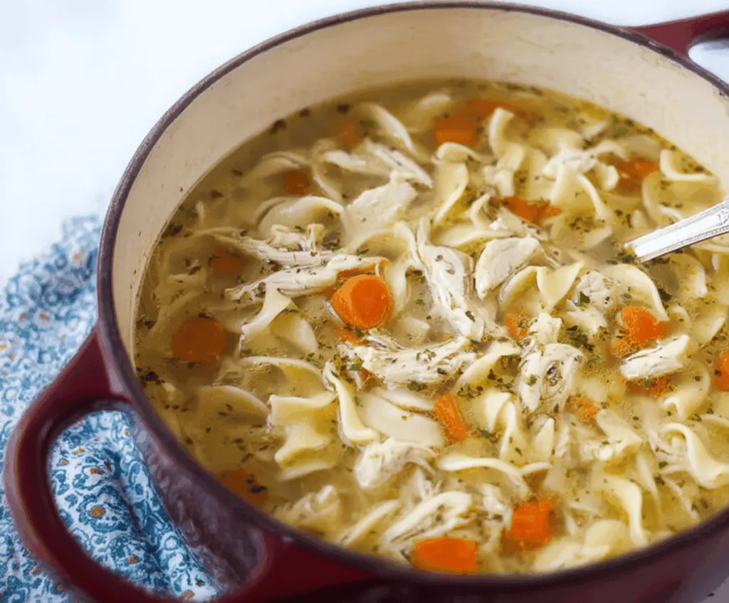 Delicious CopyCat Panera Bread Chicken Noodle Soup in a bowl with vegetables and shredded chicken, served hot with fresh herbs