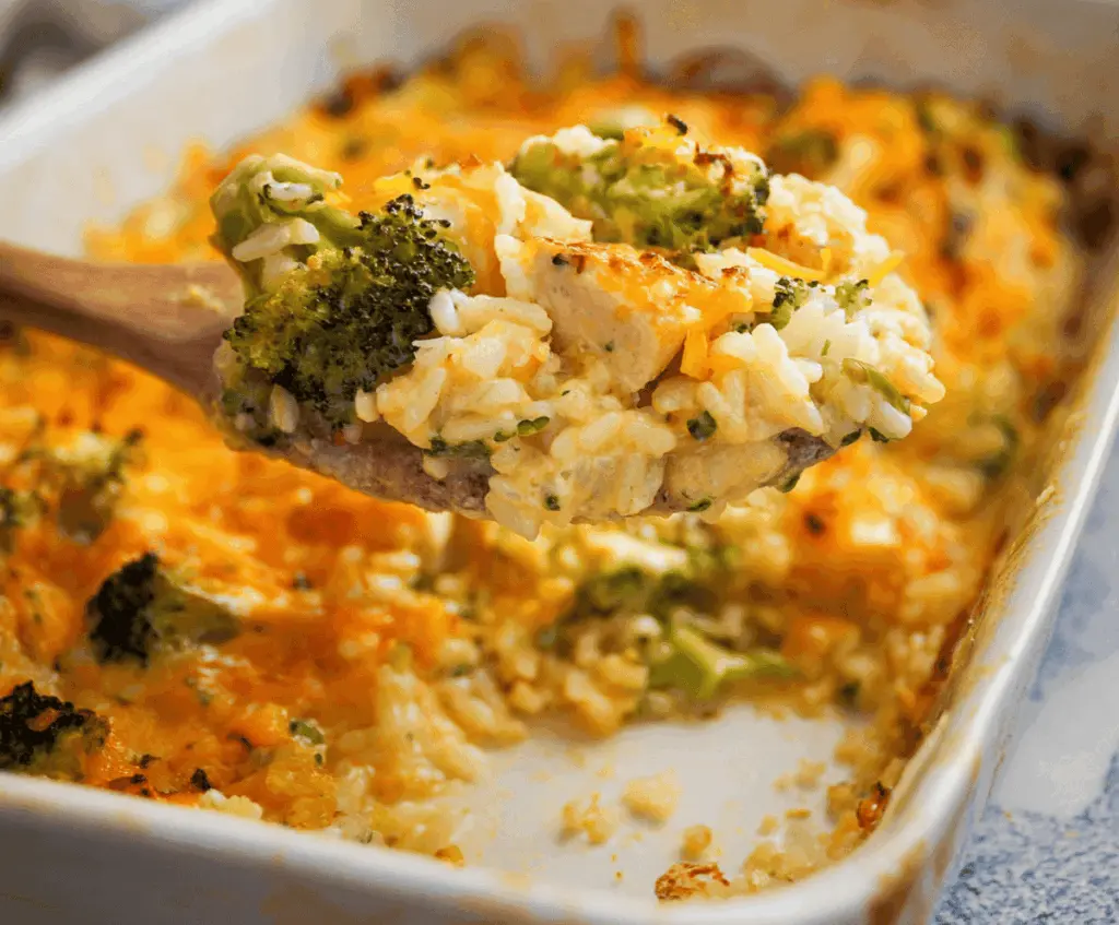 Delicious creamy chicken broccoli rice cheese casserole served in a baking dish, topped with melted cheese and fresh herbs