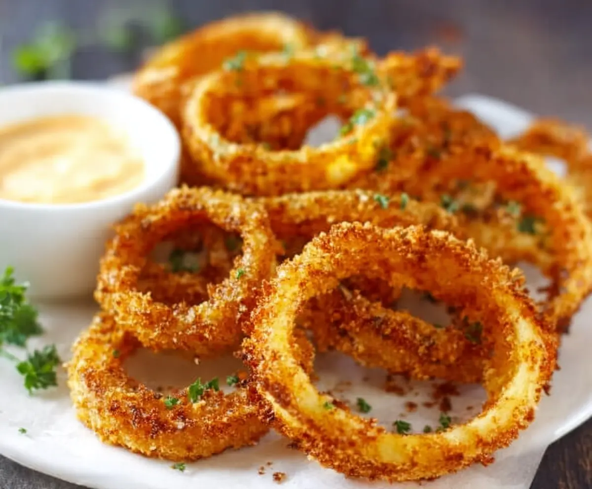 Golden crispy keto onion rings served as low-carb appetizer on a plate.
